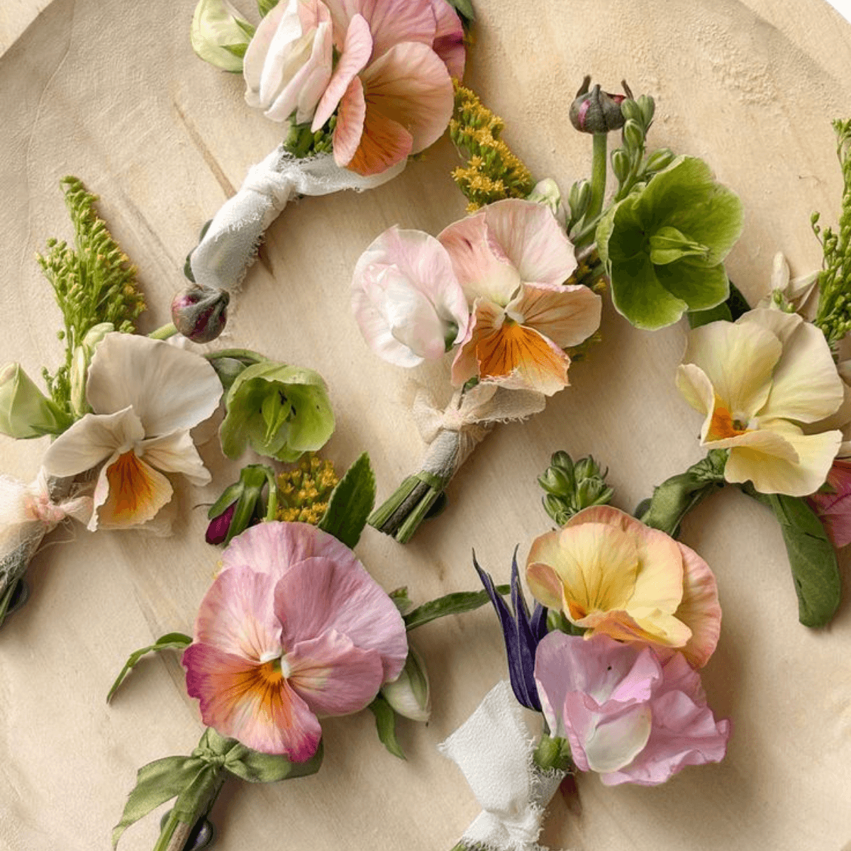 Vibrant pansy boutonnieres on wood backdrop